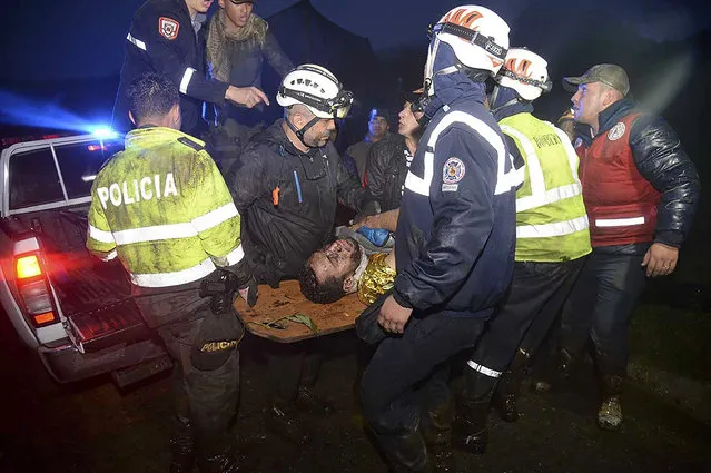 Rescuers carry one of the survivors from the LAMIA airlines charter plane carrying members of the Chapecoense Real football team that crashed in the mountains of Cerro Gordo, municipality of La Union, on November 29, 2016. A charter plane carrying the Brazilian football team crashed in the mountains in Colombia late Monday, killing as many as 75 people, officials said. (Photo by Raul Arboleda/AFP Photo)