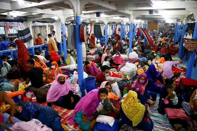 Migrant people and workers board a passenger ferry at the Sadarghat Ferry Terminal as they leave Dhaka a day before a countrywide lockdown, imposed by the government after the coronavirus disease (COVID-19) cases increased in Dhaka, Bangladesh, April 4, 2021. (Photo by Mohammad Ponir Hossain/Reuters)