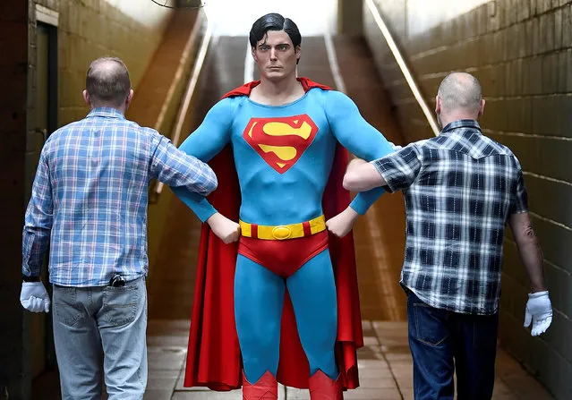 Employees pose as they carry the Superman costume worn by Christopher Reeve from the 1978 and 1980 films which goes on display at the IMAX before being auctioned later this month in London, England on September 6, 2018. (Photo by Toby Melville/Reuters)