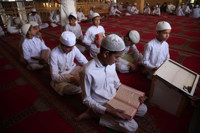 Afghan boys read holy Koran at a mosque during the Muslim holy month of Ramadan amid the coronavirus pandemic in Jalalabad, Afghanistan, 19 April 2021. (Photo by Ghulamullah Habibi/EPA/EFE)