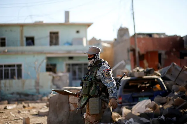 An Iraqi soldier carries a RPG as he walks among wreckage of buildings damaged from clashes in the frontline during a battle with Islamic State militants in the neighbourhood of Intisar, eastern Mosul, Iraq, December 6, 2016. (Photo by Ahmed Jadallah/Reuters)