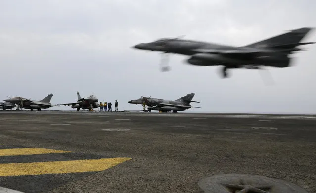 In this Tuesday, March 17, 2015 photo, a French military plane lands on the flight deck of the French Navy aircraft carrier Charles de Gaulle in the Persian Gulf. (Photo by Hasan Jamali/AP Photo)