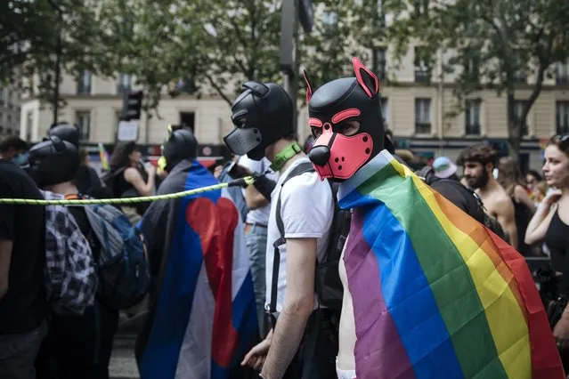 Participants wear dog masks during the annual Gay Pride march in Paris, Saturday, June 26, 2021. This year's march in Paris comes amid widespread fury and concern in Europe about legislation in EU-member nation Hungary that will ban showing content about LGBT issues to children. (Photo by Lewis Joly/AP Photo)