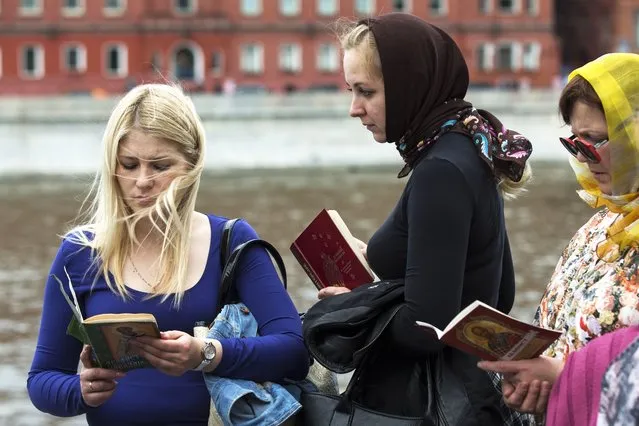 Russian Orthodox faithful hold Bibles as they line up to kiss the relics of St. Nicholas in Christ the Savior Cathedral in Moscow, Russia, on May 26, 2017. Over three decades, Russia has gone from having some of the world's least-restrictive abortion laws to being what officials call a bulwark of “traditional values”, with the health minister condemning women for prioritizing careers over childbearing. (Photo by AP Photo, File)