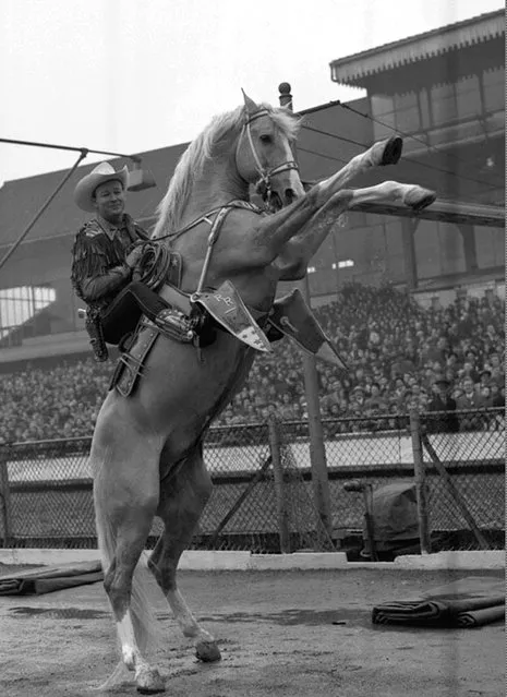 Cowboy film star Roy Rogers rides his famous horse Trigger, to greet 40,000 children at London's Harringay Arena, March 20, 1954. Rogers, and his wife Dale Evans, appeared in the special rally with U.S. Evangelist Billy Graham, unseen. (Photo by AP Photo)