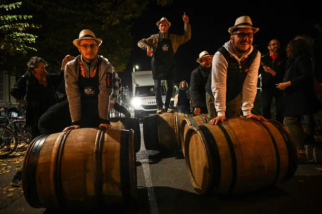 Wine-growers bring barrels of Beaujolais Nouveau to the official launch of the 2023 edition of the “Beaujolais Nouveau” wine in the streets of Lyon, central-eastern France, on November 15, 2023. (Photo by Olivier Chassignole/AFP Photo)