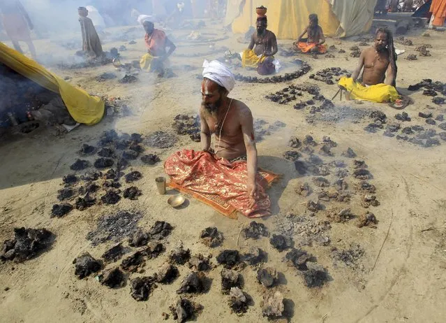 Sadhus or Hindu holy men offer prayers while sitting inside circles of burning “Upale” (or dried cow dung cakes) on the occasion to mark the Basant or spring festival, on the banks of river Ganga in Allahabad, India, February 13, 2016. Basant is celebrated mainly in the northern Indian states marking the start of the spring season. (Photo by Jitendra Prakash/Reuters)