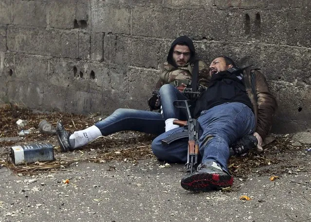 A “Free Syrian Army” fighter (L) looks at his comrade as he gets shot by sniper fire during heavy fighting in the Ain Tarma neighbourhood of Damascus January 30, 2013. (Photo by Goran Tomasevic/Reuters)