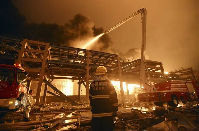 A firefighter looks on as he and his colleagues try to extinguish a fire at a petrochemical plant in Zhangzhou, Fujian province April 7, 2015. (Photo by Reuters/Stringer)
