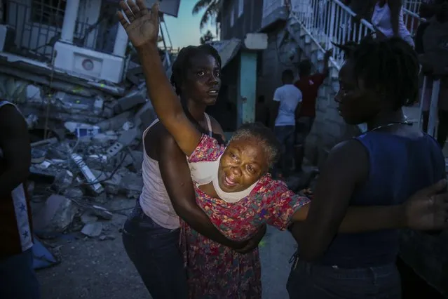 Oxiliene Morency cries out in grief after the body of her 7-year-old-daughter Esther Daniel was recovered from the rubble of their home destroyed by the earthquake in Les Cayes, Haiti, Saturday, August 14, 2021. (Photo by Joseph Odelyn/AP Photo)