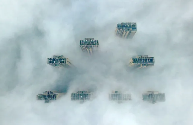 This aerial view shows the tops of highrise buildings poking out from heavy fog in Yangzhou, in China's eastern Jiangsu province on January 14, 2019. Authorities in the city issued a fog alert with heavy fog reducing visibility to 50 meters (164 ft.). (Photo by AFP Photo/Stringer)