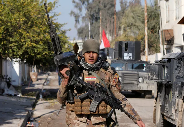 A member of Iraqi Special Operations Forces (ISOF) walks during an operation to clear the al-Andalus district of Islamic State militants, in Mosul, Iraq, January 16, 2017. (Photo by Muhammad Hamed/Reuters)