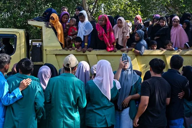 Rohingya refugees crowd into a vehicle for relocation to a nearby government building after demonstrating university students forced them out of the current government facility, in Banda Aceh on December 27, 2023. Hundreds of university students in Indonesia's westernmost province stormed a temporary shelter for more than a hundred Rohingya refugees on December 27, forcing them to leave in the latest rejection of the persecuted Myanmar minority. (Photo by Chaideer Mahyuddin/AFP Photo)