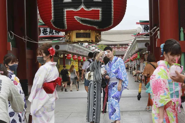 People wearing yukata visit Asakusa area known for the Sensoji temple and nearby shopping district in Tokyo Friday, August 13, 2021. (Photo by Koji Sasahara/AP Photo)
