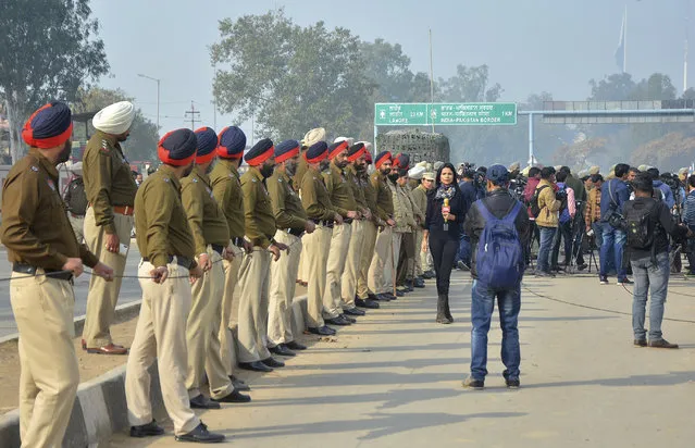 Indian policemen and media person wait for the return of Indian pilot at India Pakistan border at Wagah, 28 kilometers (17.5 miles) from Amritsar, India, Friday, March 1, 2019. Pakistan is preparing to hand over a captured Indian pilot as shelling continued for a third night across the disputed Kashmir border even as the two nuclear-armed neighbors seek to defuse the most serious confrontation in two decades. (Photo by Prabhjot Gill/AP Photo)
