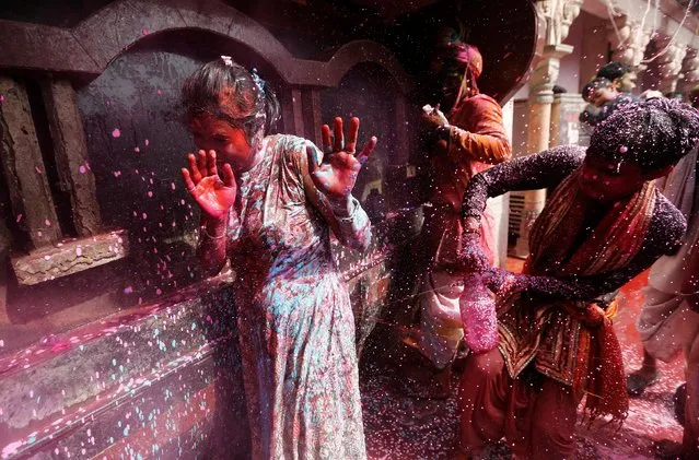A boy sprays coloured water on a girl during religious religious festival of Holi inside a temple in Nandgaon village, in the state of Uttar Pradesh, India, March 16, 2019. (Photo by Adnan Abidi/Reuters)