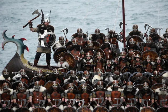 Participants dressed as Vikings pose by a long boat in the annual Up Helly Aa festival in Lerwick, Shetland Islands, on January 31, 2017. Up Helly Aa celebrates the influence of the Scandinavian Vikings in the Shetland Islands and culminates with up to 1,000 “guizers” (men in costume) throwing flaming torches into their Viking longboat and setting it alight later in the evening. (Photo by Andy Buchanan/AFP Photo)
