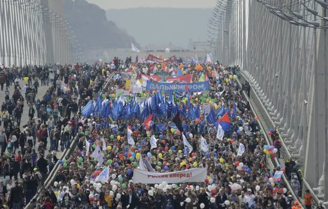 People walk with flags and banners along a bridge over the Golden Horn bay during a May Day rally in the Russian far-eastern city of Vladivostok May 1, 2015. (Photo by Yuri Maltsev/Reuters)
