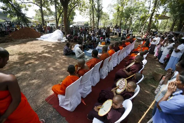 Buddhist monks pray for the dead elephant Hemantha during a religious ceremony at a Buddhist temple in Colombo March 15, 2016. Elephant Hemantha, which died from injuries to its feet, was under medical treatment for the last six months. The elephant used to march at street parades during festivals held by the temple. Elephant Hemantha died at age 23. Wild elephants have long lifespans, reaching 60–70 years of age. (Photo by Dinuka Liyanawatte/Reuters)