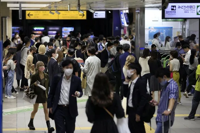 People wait at a train station in Tokyo early Friday, October 8, 2021, after a powerful magnitude 5.9 earthquake has shaken the Tokyo area late Thursday, temporarily halting trains and subways. (Photo by Kiichiro Sato/AP Photo)