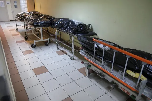 Stretchers with black body bags containing bodies of COVID-19 victims are seen deposited on a hallway leading to Bucharest's University Hospital morgue, October 29, 2021. Romania, at the forefront of a wave of COVID-19 sweeping across central and eastern Europe, has reported record numbers of daily coronavirus deaths and infections in October and says that the hospital system is stretched to breaking point. (Photo by Octav Ganea/Inquam Photos via Reuters)