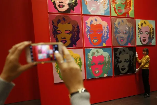 An employee poses with ten screenprints of Marilyn Monroe by Andy Warhole as part of the exhibition “American Dream: pop to the present” at the British Museum in London, Britain  February 10, 2017. (Photo by Stefan Wermuth/Reuters)
