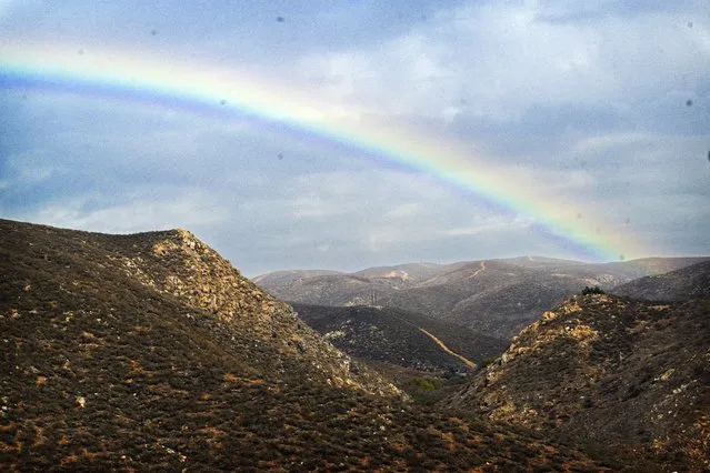 A rainbow appears over the Cajalco hills near Corona, Calif., on cloudy and slightly rainy Tuesday, December 19, 2023. (Photo by Anjali Sharif-Paul/The Orange County Register via AP Photo)