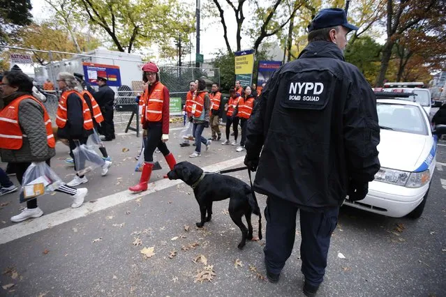 A New York Police Department officer and a bomb sniffing dog patrol the finish line area before the start of the New York City Marathon in New York, November 3, 2013. In addition to cheering supporters, runners in this Sunday's New York City Marathon will also be monitored by bomb-sniffing dogs, police scuba divers and surveillance helicopters to prevent an attack similar to the one at the Boston race earlier this year. (Photo by Mike Segar/Reuters)