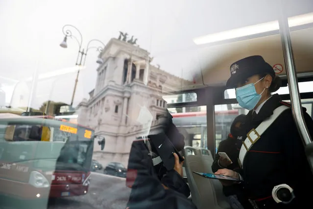 Passengers have their coronavirus disease (COVID-19) health passes, known as a Green Pass, checked as they board a bus the day the government restricts access of unvaccinated to indoor venues, in Rome, Italy on  December 6, 2021. Picture taken behind a window. (Photo by Yara Nardi /Reuters)