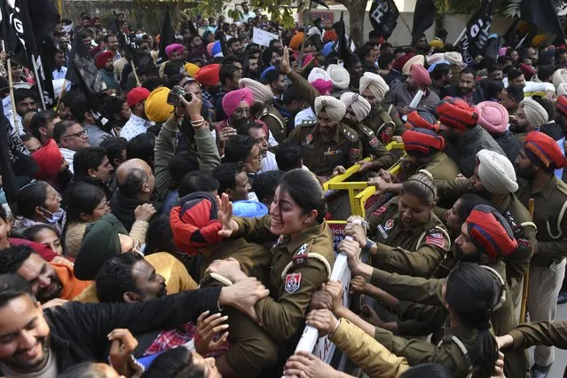Protesting workers from the National Health Mission (NHM) try to cross a police barricade during a protest march towards the residence of Punjab Deputy Chief Minister in Amritsar on December 10, 2021 demanding better work regulations. (Photo by Narinder Nanu/AFP Photo)