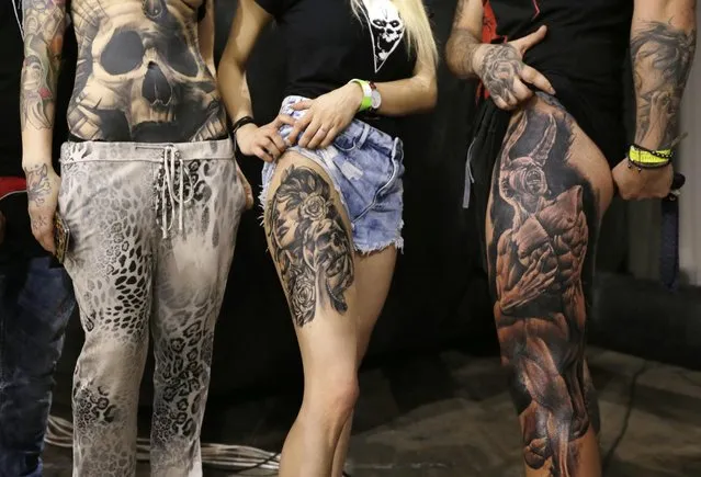 Heavily tattooed youths pose for their friends as they take part in a contest during the annual Athens Tattoo Convention in Athens, Sunday, May 17, 2015. (Photo by Thanassis Stavrakis/AP Photo)