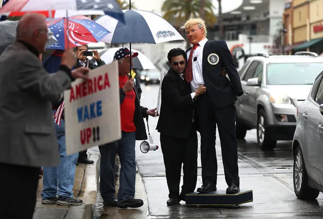 A man carries a mannequin dressed as U.S. President Donald Trump past supporters during a rally in favor of the “America First” on February 27, 2017 in Brea, California. Dozens of supporters of U.S. President Donald Trump held a rally outside the office of U.S. Rep. Ed Royce (R-CA) in support of the “America First” agenda that the Trump administration is pushing forward.  (Photo by Justin Sullivan/Getty Images)