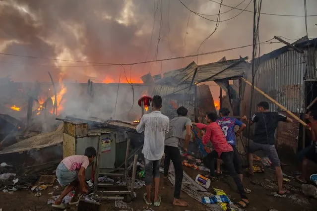 Men attempt to douse a fire which engulfed a slum dwelling on March 24, 2024 in the Banani neighbourhood of Dhaka, Bangladesh. (Photo by Abhishek Chinnappa/Getty Images)