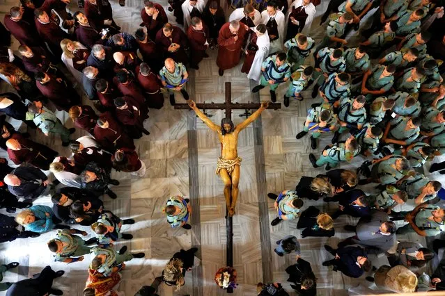 Spanish legionnaires and penitents stand next to a statue of Christ, known as the “Christ of the Good Death”, inside a church after the governing body of the Ecce-Homo brotherhood decided that penance could not be carried out in the streets due to the heavy rain of the Nelson storm during the Holy Week, in Ronda, Spain on March 28, 2024. (Photo by Jon Nazca/Reuters)