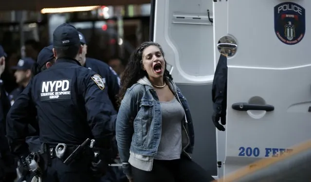 A demonstrator is loaded into a police van after being detained inside the venue of the 2016 New York State Republican Gala while protesting against the Republican U.S. presidential candidate Donald Trump in midtown Manhattan in New York City, April 14, 2016. (Photo by Mike Segar/Reuters)