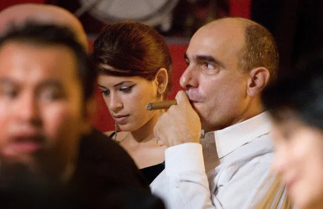 Alejandro Castro (C-right) son of the Cuban President Fidel Castro, smokes a cigar, 03 March, 2007 during the final dinner of the Festival IX Cuban Cigars Festival in Havana. The presence of several of Castro's children in the event, offered one more symptom on the improvement of the health of Fidel Castro. (Photo by Adalberto Roque/AFP Photo)