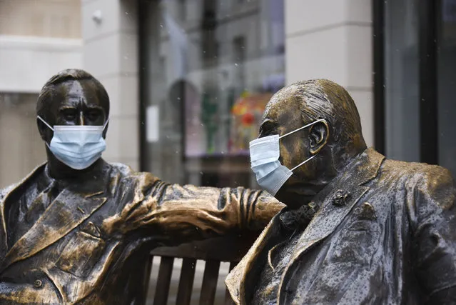 Face coverings on the statues of former US President Franklyn D. Roosevelt, left, and former British Prime Minister Winston Churchill in Mayfair, London, Sunday, February 7, 2021, as the third national lockdown, due to the COVID-19 outbreak, continues. (Photo by Alberto Pezzali/AP Photo)