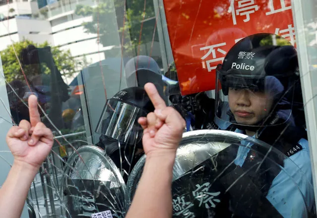 Protester gestures as he tries to break into the Legislative Council building where riot police are seen, during the anniversary of Hong Kong's handover to China in Hong Kong, China on July 1, 2019. (Photo by Thomas Peter/Reuters)