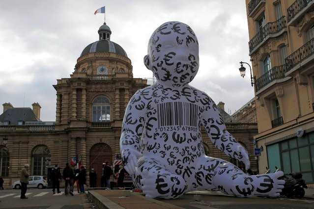 A giant inflatable baby, installed by members of the “Manif Pour Tous” (Demonstration For All) is seen during a protest against medically assisted procreation PMA, surrogate motherhood GPA and the bioethics bill in front of the French Senate in Paris, France on February 2, 2021. (Photo by Gonzalo Fuentes/Reuters)
