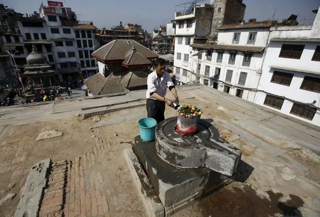 A man offers prayers at the site of a collapsed temple during the first anniversary of the earthquake in Kathmandu, Nepal, April 24, 2016. (Photo by Navesh Chitrakar/Reuters)