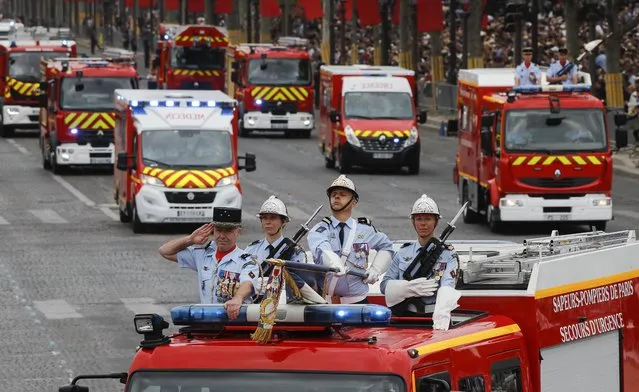 Firefighters drive on the Champs-Elysees avenue during the Bastille Day parade in Paris, France, Sunday July 14, 2019. (Photo by Michel Euler/AP Photo)