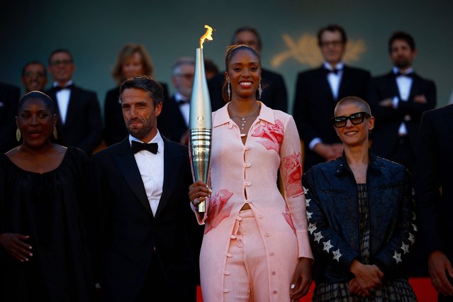French basketball player Iliana Rupert holds the Olympic Torch next to President of the Paris 2024 Olympics and Paralympics Organising Committee (Cojo) Tony Estanguet (L) and French paracyclist Marie Patouillet (R) for the screening of the film “Marcello Mio” at the 77th edition of the Cannes Film Festival in Cannes, southern France, on May 21, 2024, as part of the Olympics torch relay. (Photo by Sarah Meyssonnier/Reuters)
