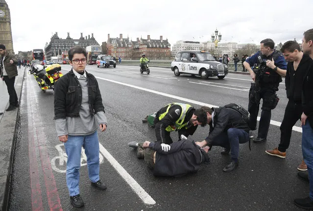 Injured people are assisted after an incident on Westminster Bridge in London, Britain on Wednesday, March 22, 2017. (Photo by Toby Melville/Reuters)