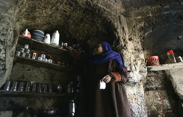 Shah Begum, a Kashmiri woman, works in the kitchen of her house inside the ruins of Dara Shikuh monument in Srinagar March 8, 2007. (Photo by Danish Ismail/Reuters)