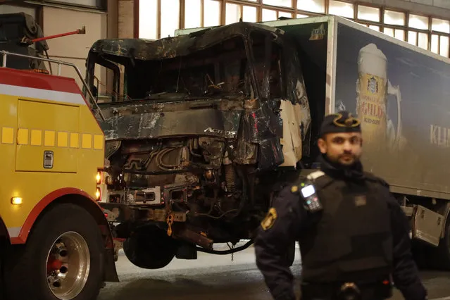 A destroyed truck is pull away by a service car after it was driven into a department store in Stockholm, Sweden, Saturday, April 8, 2017. The hijacked beer truck plowed into pedestrians at the central Stockholm department store on Friday, sending screaming shoppers fleeing in panic in what Sweden's prime minister called a terrorist attack. (Photo by Markus Schreiber/AP Photo)