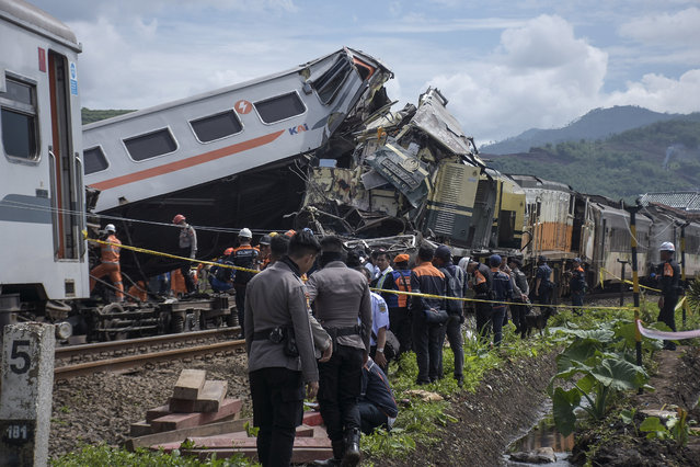 Rescuers inspect the wreckage after the collision between two trains in Cicalengka, West Java, Indonesia, Friday, January 5, 2024. The trains collided on Indonesia's main island of Java on Friday, causing several carriages to buckle and overturn and killing at least a few people, officials said. (Photo by Abdan Syakura/AP Photo)