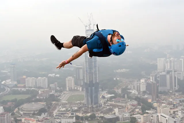 A BASE jumper leaps from Kuala Lumpur Tower on a hazy day during International Jump Malaysia 2019 in Kuala Lumpur, Malaysia, September 26, 2019. (Photo by Chong Voon Chung/Xinhua News Agency/Barcroft Media)