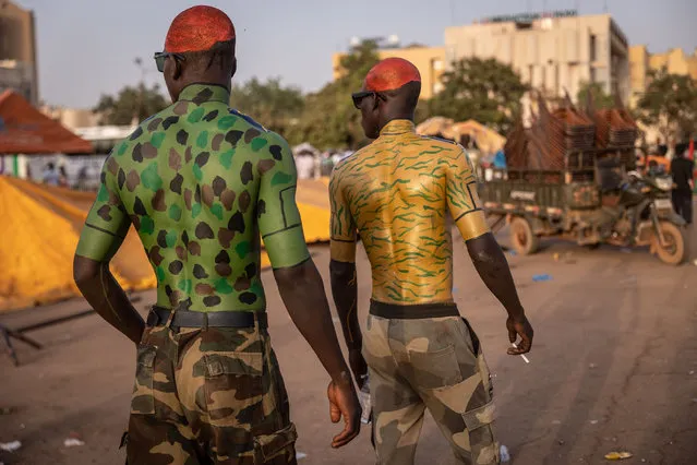 Men with military body painting walk during a gathering to show support to the military in Ouagadougou, on February 19, 2022. (Photo by Olympia de Maismont/AFP Photo)