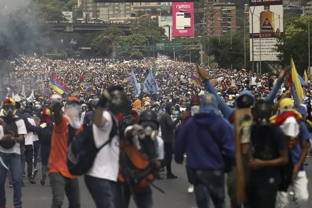 Thousands of opponents of President Nicolas Maduro march in Caracas, Venezuela, Wednesday, April 26, 2017. Security forces blocked anti-government protesters that attempted to march to the Ombudsman's office in downtown in another day of protests that have already claimed dozens of lives since the start of April. (Photo by Fernando Llano/AP Photo)