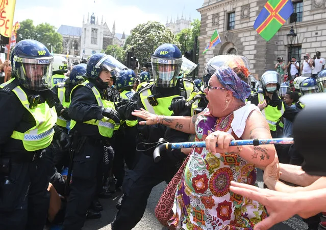 Demonstrators scuffle with police during an anti lockdown protest in Parliament square in London, Britain, 19 July 2021. The British Prime Minister, Boris Johnson is self isolating in Chequers during what has been dubbed as 'freedom day' after England lifted many of its remaining COVID-19 restrictions on 19 July. (Photo by Facundo Arrizabalaga/EPA/EFE)